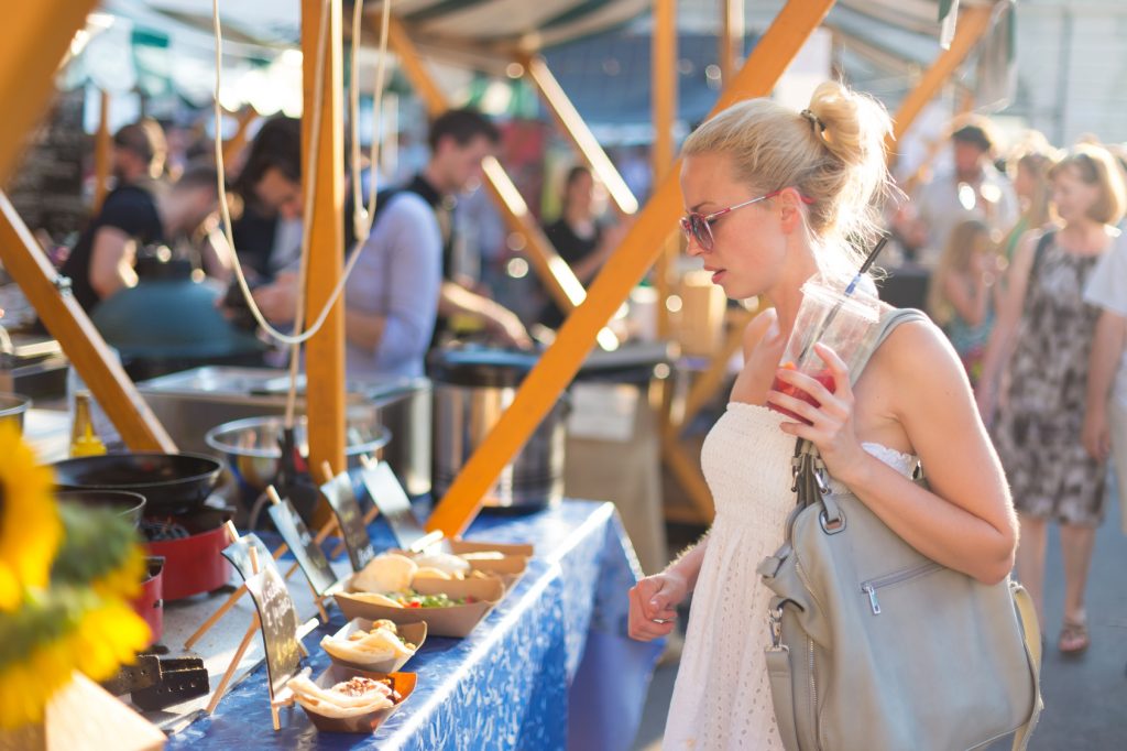 Woman buying meal at street food festival.