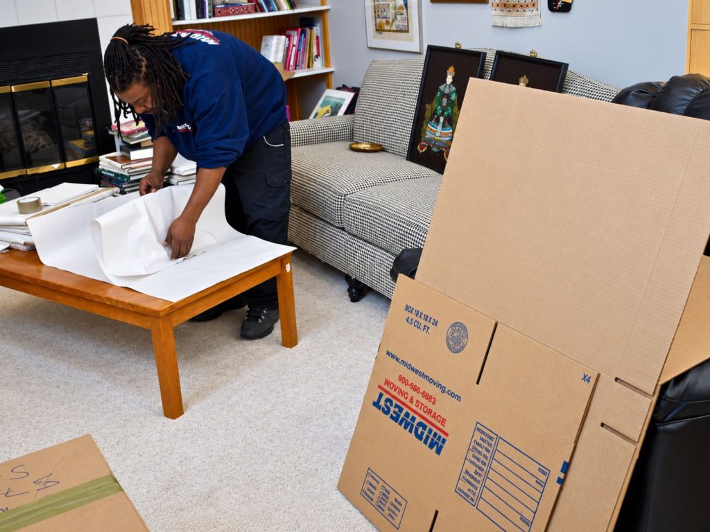 mover professionally packing the household items for a move mover professionally packing the household items for a move