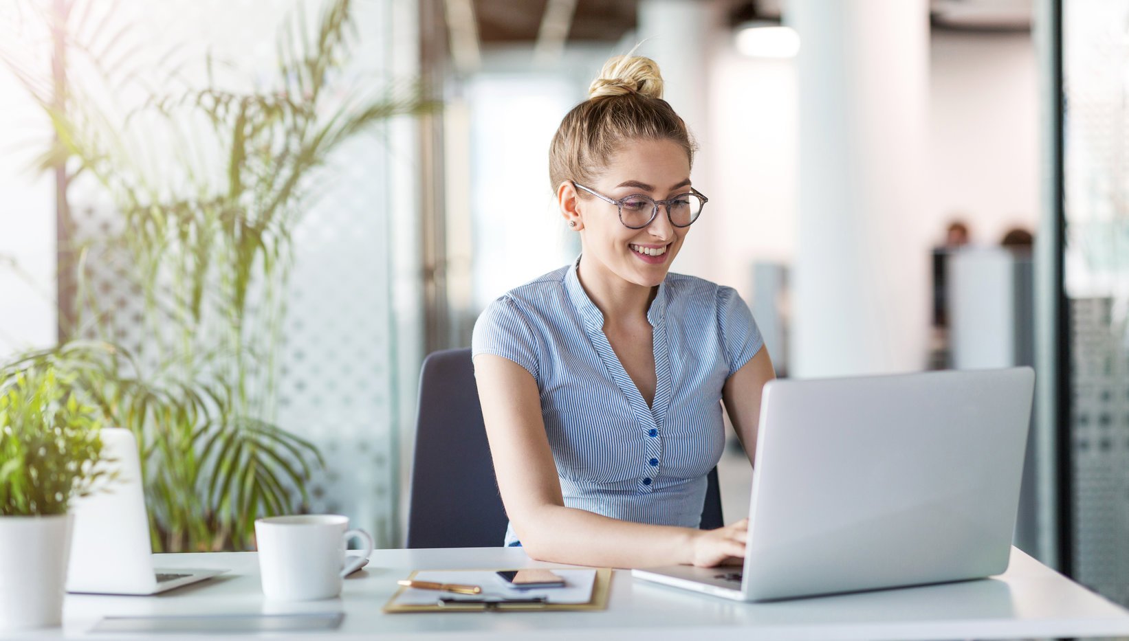 Young business woman working on laptop in office