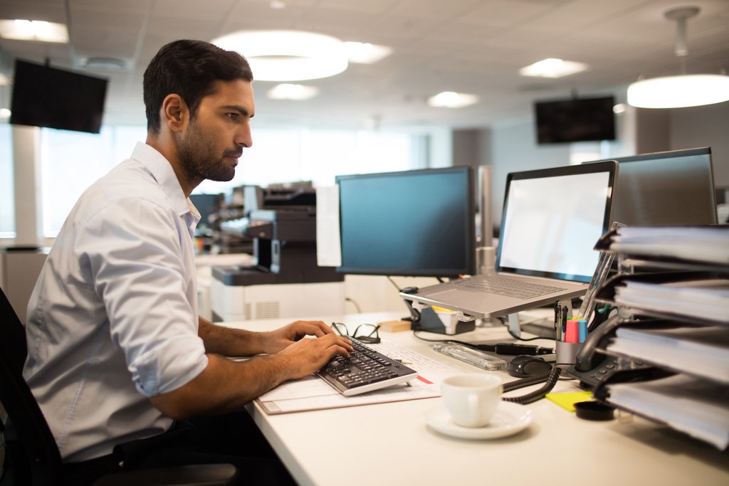 Focused businessman using desktop pc in office