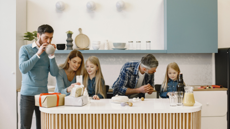 Family in kitchen looking at housewarming gifts
